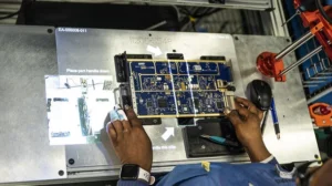 Over-the-shoulder look at manufacturer at L3Harris Technologies assembling electronics with LightGuide projected augmented reality work instructions